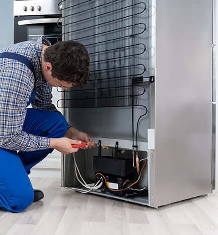 Technician repairing a refrigerator in Cape Town